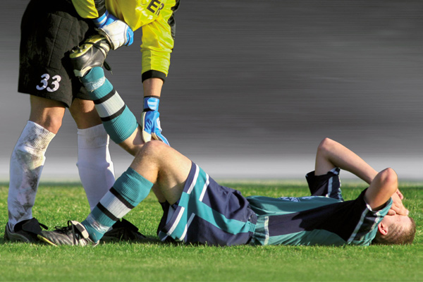 Fußballer mit Muskelkrampf beim Spiel | Krämpfe vermeiden durch Isodrinks